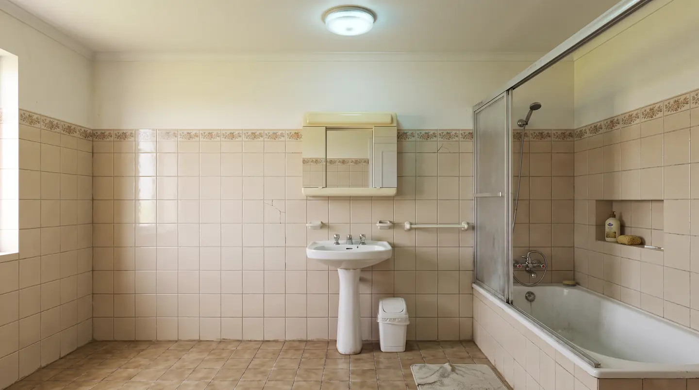 Antes: casa de banho antiga com azulejo bege, banheira e lavatório de coluna